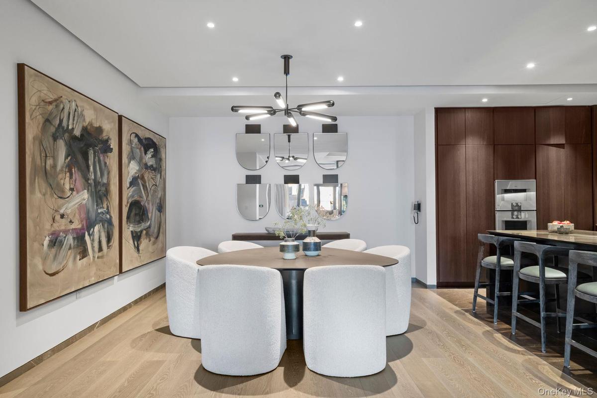Dining area with light wood-style floors, recessed lighting, and an inviting chandelier