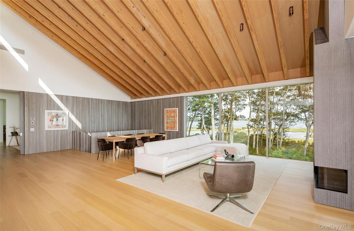 Living room featuring light wood-style flooring, high vaulted ceiling, wooden ceiling, and a water view