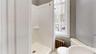 Bathroom with a shower, radiator, sink, and toilet