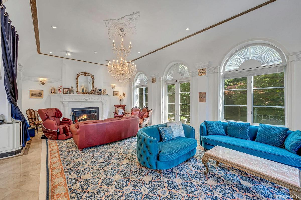Living room with a glass covered fireplace, recessed lighting, a chandelier, and crown molding