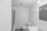 Full bathroom featuring a wainscoted wall, vanity, shower / bath combo with shower curtain, and a decorative wall