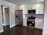 Kitchen featuring stainless steel appliances, decorative backsplash, white cabinetry, and recessed lighting
