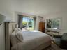 Bedroom featuring multiple windows and a wall mounted air conditioner