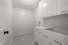 Well-organized laundry room with extensive white cabinets.