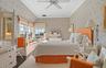 Bedroom featuring visible vents, ornamental molding, a ceiling fan, dark wood finished floors, and wallpapered walls