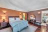 Hardwood flooring, crown molding, wall sconces, wood door, and a built-in vanity with mirror