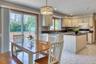 Kitchen featuring hanging light fixtures, backsplash, range with electric cooktop, under cabinet range hood, and recessed lighting
