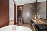 Full bathroom with a soaking tub, visible vents, tile walls, and vanity