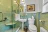 Newly renovated en-suite full bath featuring walk-in shower, subway walls, basketweave tile flooring, and wainscoting