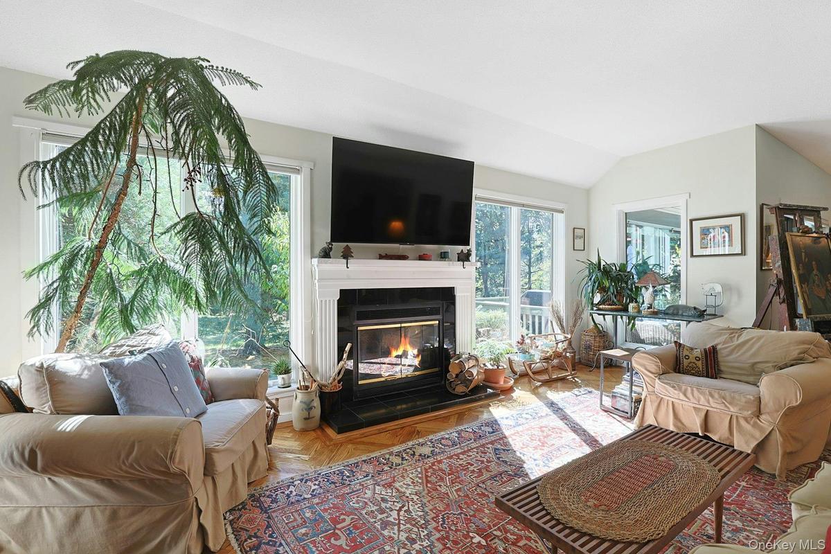 Living room featuring a glass covered fireplace and lofted ceiling