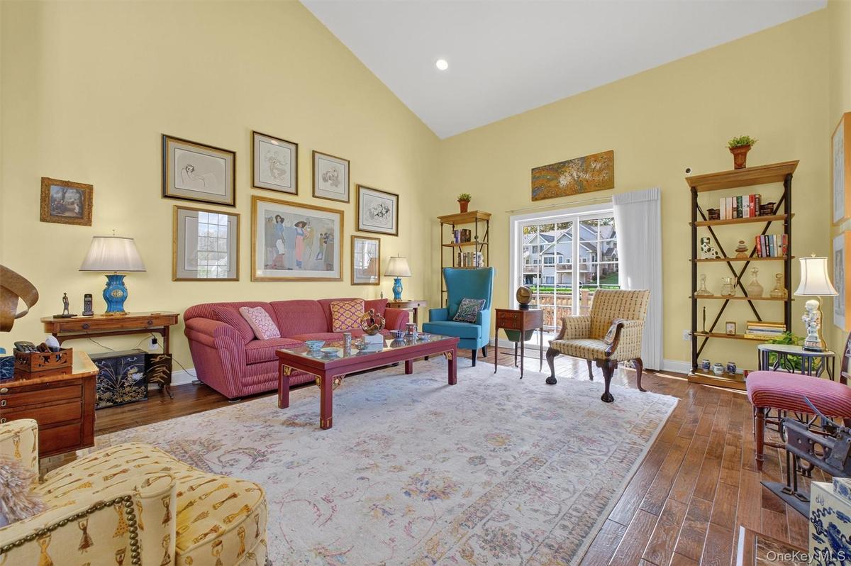 Living room with high vaulted ceiling, dark wood-style floors, and recessed lighting