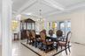 Dining space with ornamental molding, coffered ceiling, beam ceiling, a water view, and a chandelier