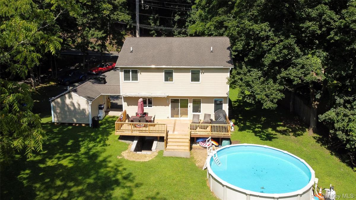 Aerial view of part of the backyard, deck, breezeway, and detached garage.