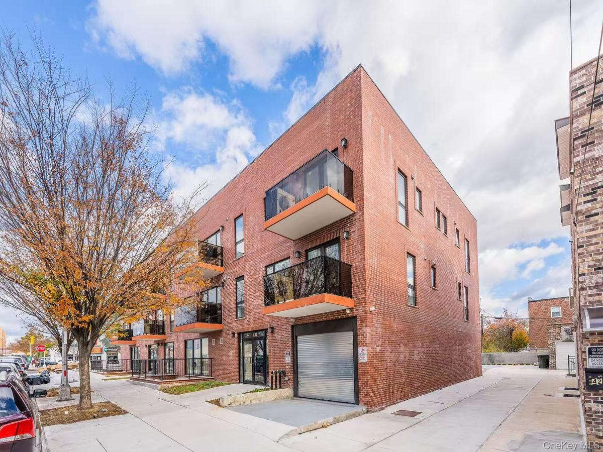 View of apartment building / complex with driveway and a garage