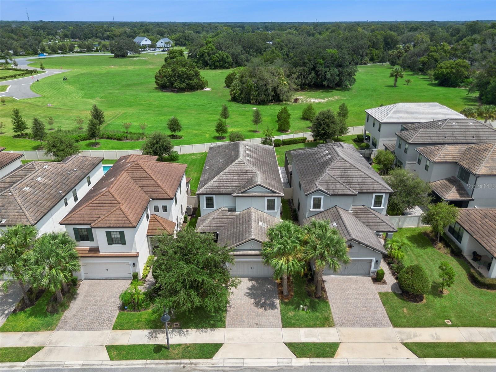 1287 Verdant Glade Pl, showcasing an attractive two-story exterior, paver driveway, and a standout setting with expansive green space directly beyond 