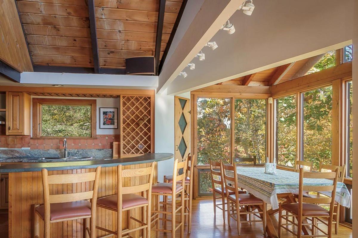 Bar featuring wooden ceiling, indoor wet bar, wood finished floors, vaulted ceiling with beams, and a sink