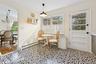 Dining space featuring healthy amount of natural light, light tile patterned floors, ornamental molding, a chandelier, and a baseboard heating unit