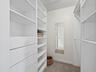 There is a large walk-in closet with built-in shelving for convenience.