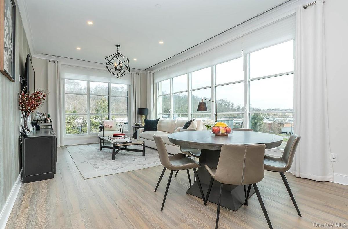 The dining area embraces northeast vistas, framed by expansive walls of windows that flood the space with natural light.