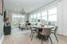 The dining area embraces northeast vistas, framed by expansive walls of windows that flood the space with natural light.