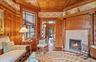 Living area with wooden ceiling, wood finished floors, ornamental molding, and a tile fireplace