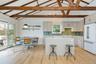 Kitchen with high end fridge, decorative backsplash, light wood-style floors, a center island, and decorative light fixtures
