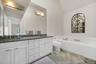 Bathroom with a garden tub, double vanity, a sink, and toilet