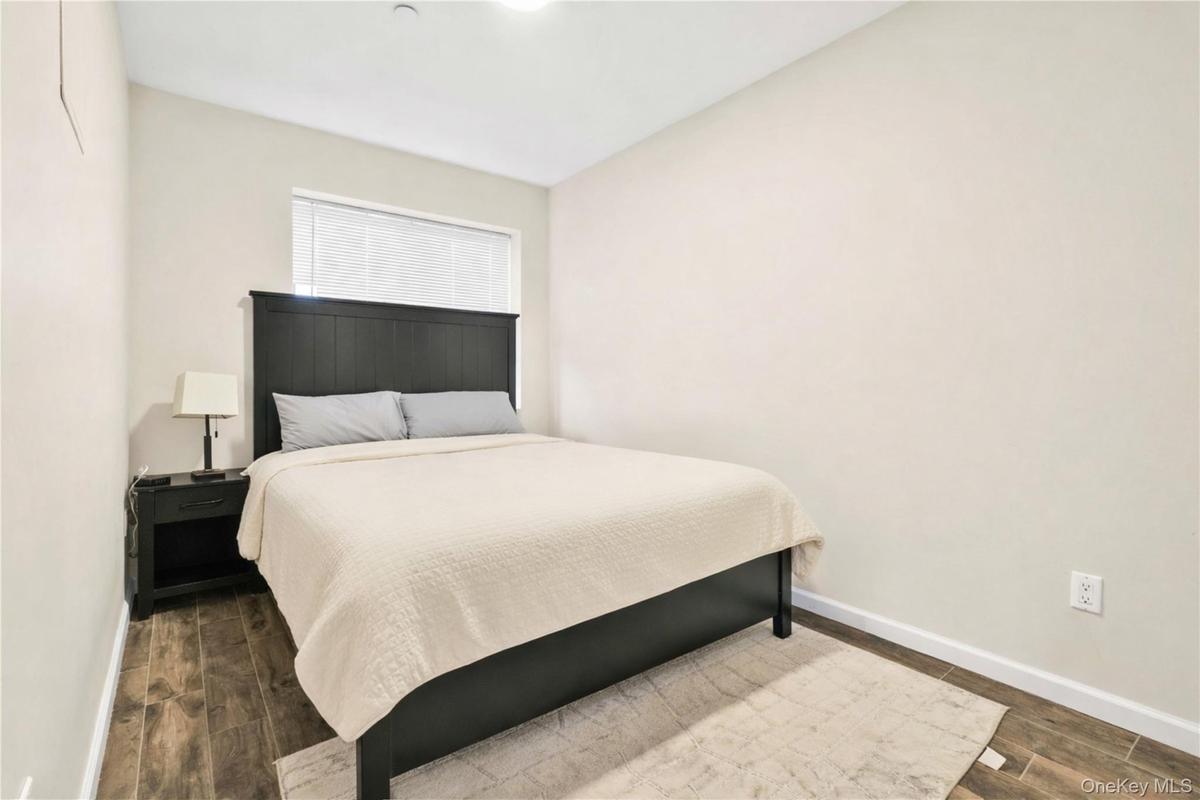 Bedroom featuring dark wood-type flooring and baseboards