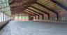 An attached 200' x 90' indoor riding ring with equestrian sand with fiber footing, sound system, and retractable windows.