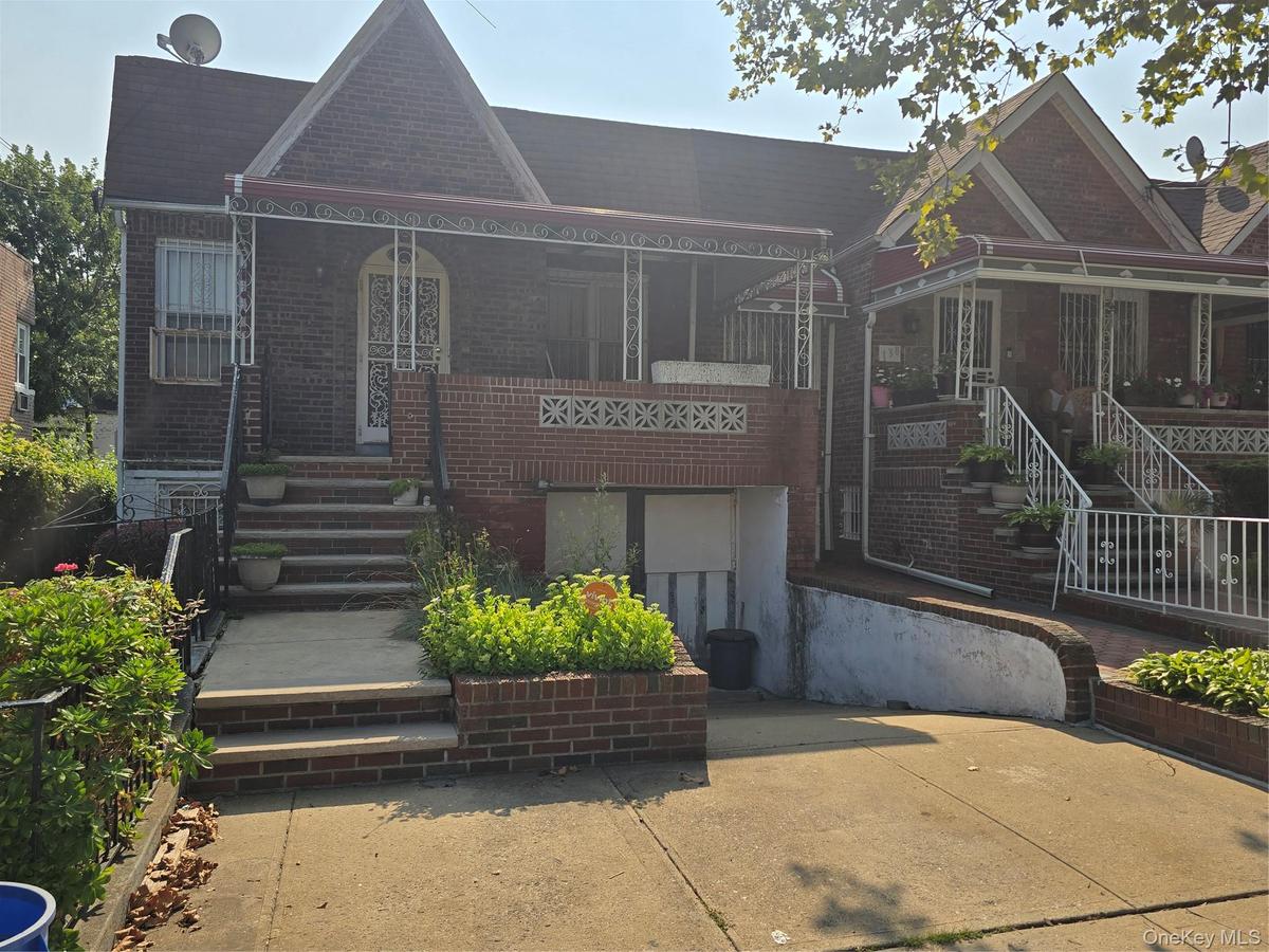 View of front of house featuring brick siding, stairs, and covered porch
