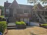View of front of house featuring brick siding, stairs, and covered porch
