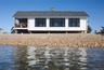 View of front of home featuring a water view, board and batten siding, a chimney, and roof with shingles