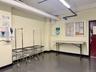 Community laundry room featuring multiple front-loading washing machines, durable flooring, and overhead fluorescent lighting