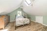 Upstairs Bedroom with lofted ceiling with skylight, an AC wall unit, hardwood / wood-style floors, and a closet