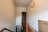 Hallway featuring an upstairs landing and tile patterned floors