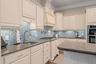 Thoughtfully designed custom kitchen featuring a hidden pantry along with built-in cutting board, trash disposal, and sponge storage for a clean, seam