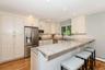 Kitchen with stainless steel appliances, a kitchen bar, a peninsula, white cabinets, and recessed lighting