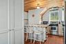 Kitchen featuring a wood-panel ceiling, stainless steel range, and window