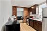 Kitchen featuring wood-finish flooring and an exposed brick accent wall