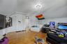 Sloped ceiling room featuring wood-finish flooring, a double window, and a flush-mount light fixture