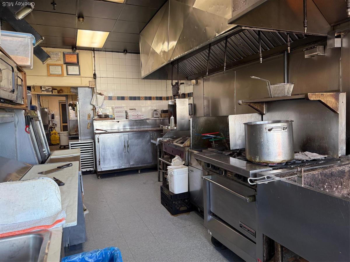 Kitchen featuring decorative backsplash, tile patterned floors, and stainless steel countertops