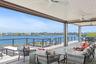 Wooden deck with an outdoor hangout area, a ceiling fan, and a water view