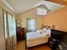 4 - Bedroom with lofted ceiling, visible vents, and wood finished floors