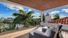 Covered terrace overlooking canal and palms
