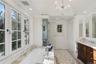 Full bathroom with a garden tub, vanity, lofted ceiling, crown molding, and a chandelier