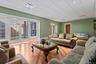 Spacious living area featuring wood-finish flooring, recessed lighting, and a grid ceiling
