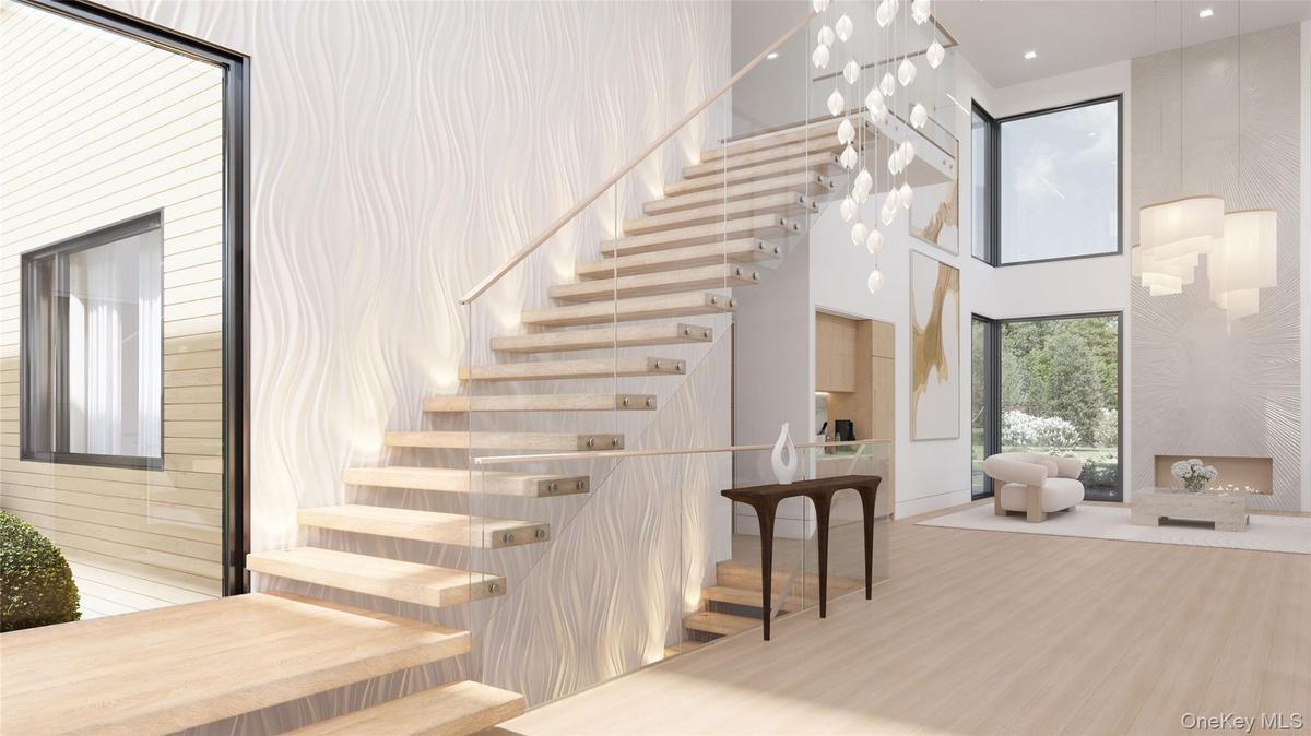 A floating staircase framed by custom wall detailing, soft illumination, and expansive glazing that draws in natural light from every angle.