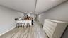 Kitchen featuring a breakfast bar area, stainless steel refrigerator, a baseboard radiator, kitchen peninsula, and white cabinets