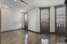 Empty room featuring a baseboard radiator, dark wood-style floors, track lighting, and cooling unit