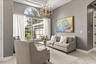 Formal living room has coffered ceilings and updated chandelier